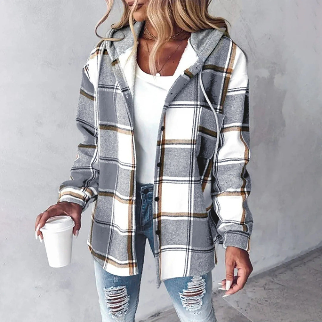 A woman wearing a grey and white checked hooded jacket with a button front