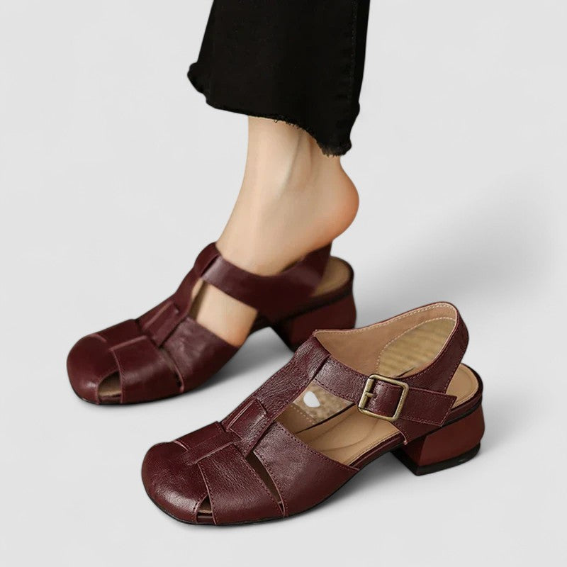 A woman in burgundy closed-toe woven sandals with a low block heel, comfortable browsing a market.