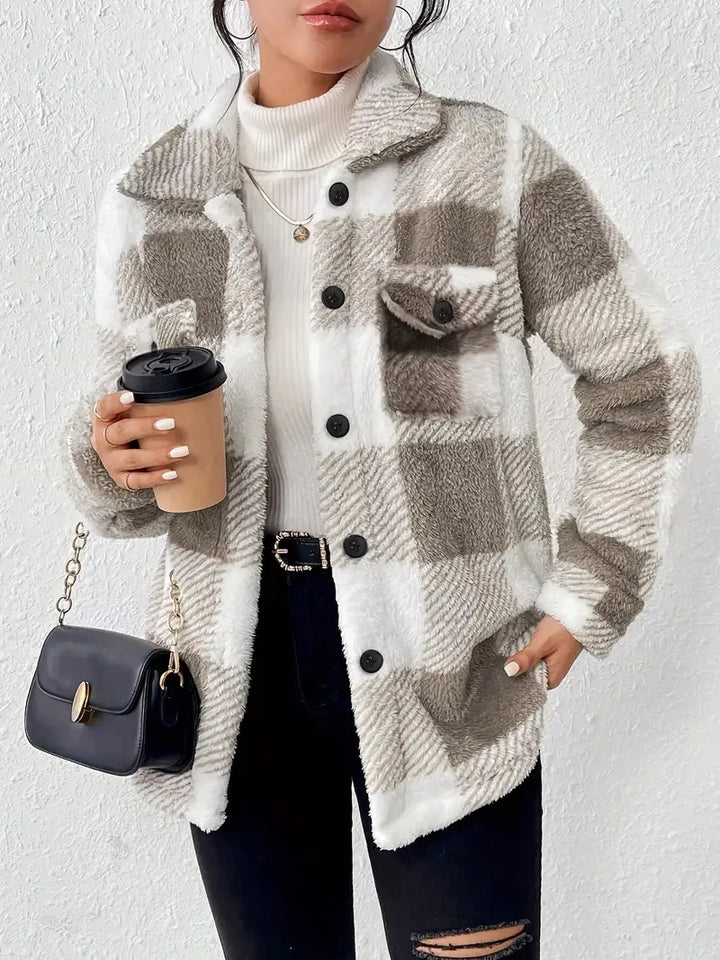 A woman wearing a soft checked jacket over casual clothes on a cool fall morning.