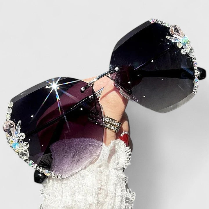 A woman at a special occasion wearing rimless sunglasses with sparkling diamanté accents, catching the light.