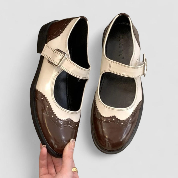 A woman wearing two-tone black and cream Mary Jane shoes, steady and comfortable on an evening out.