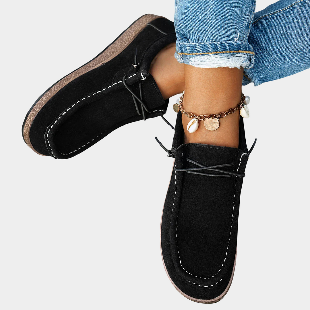 A woman wearing plain black lace-up platform comfort shoes while running errands.