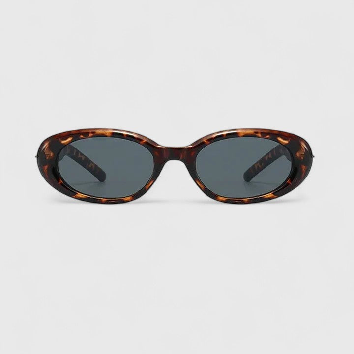A woman in the city wearing chic oval sunglasses, confident and stylish in the sun.