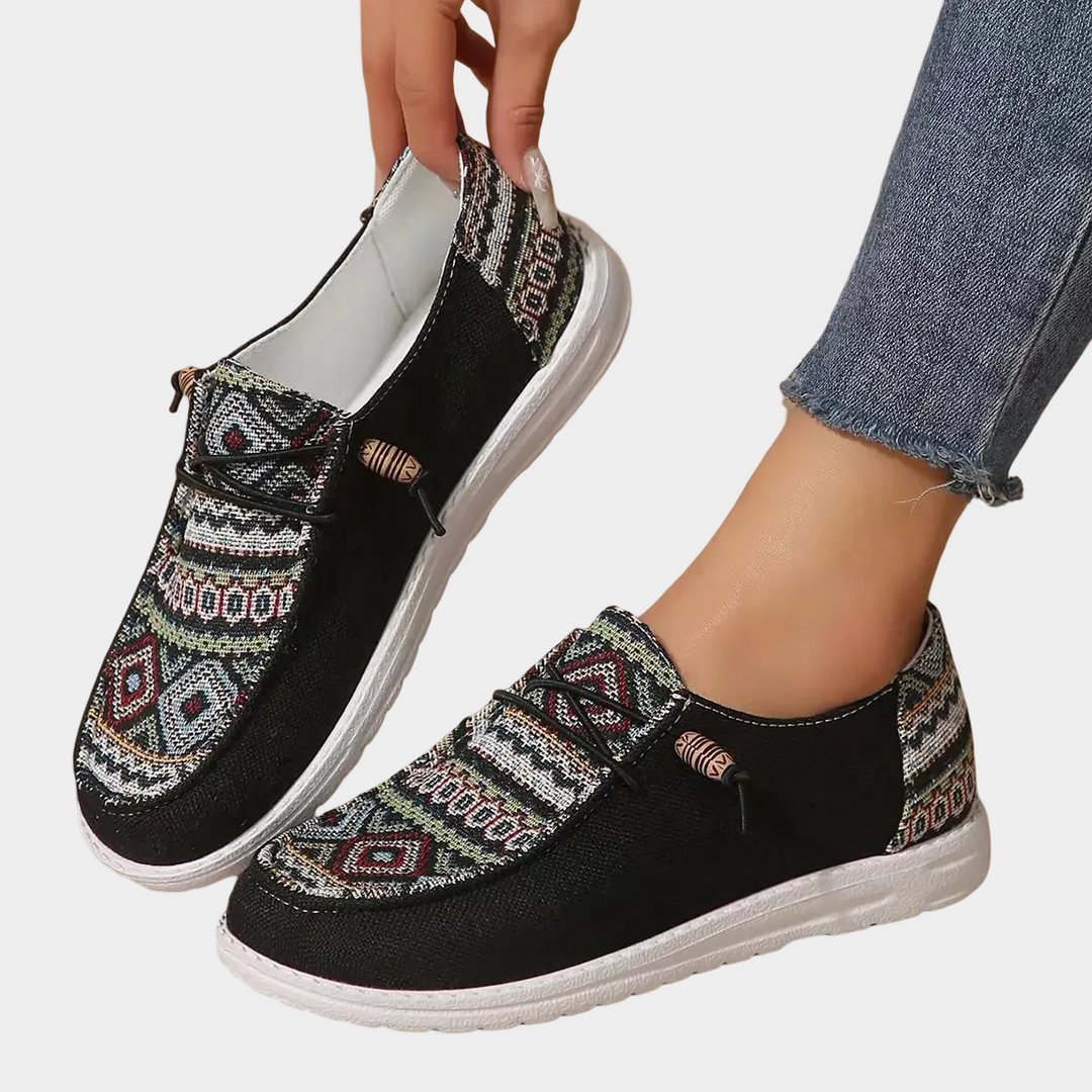 A woman walking through town wearing lightweight boho-print lace-up comfort shoes.