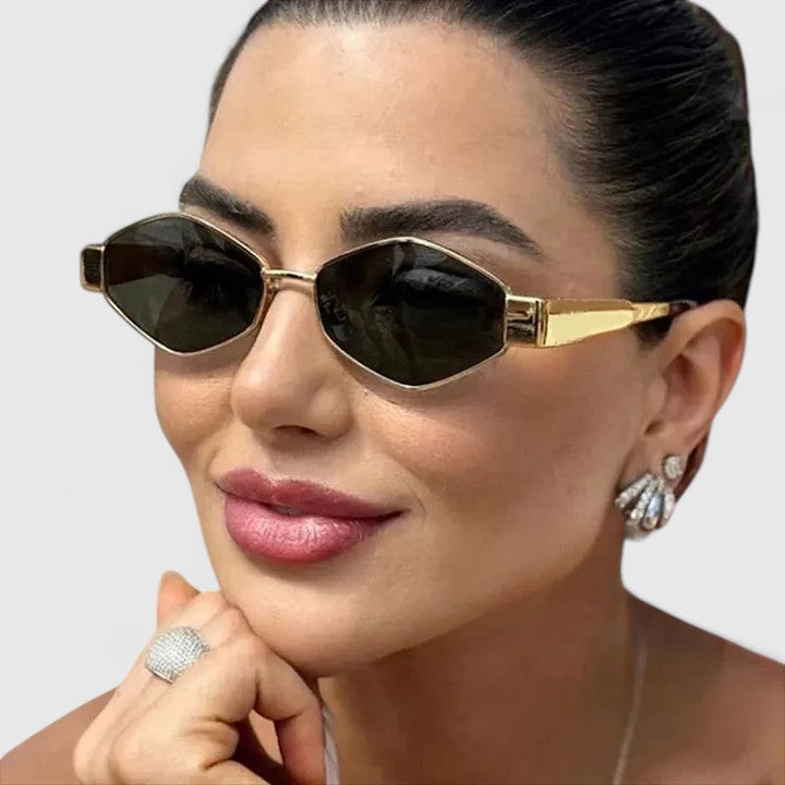 A woman wearing retro hexagonal metal-frame sunglasses on a sunny street.