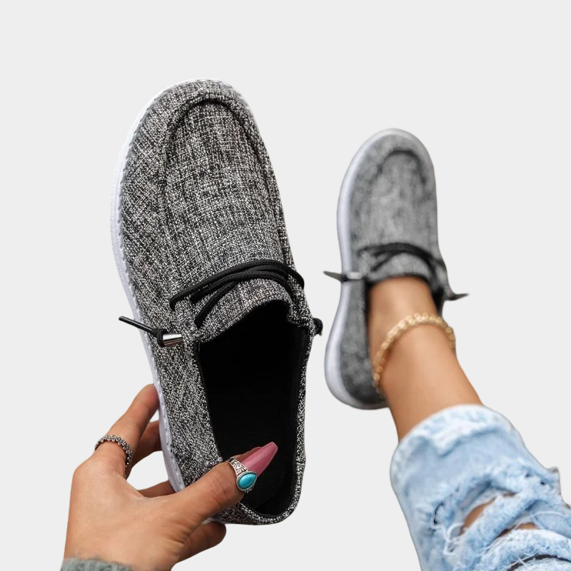 A woman wearing dark grey lace-up comfort shoes while out and about.