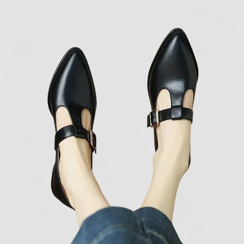 A woman in beige Mary Jane shoes with a mid block heel, poised at a daytime wedding.