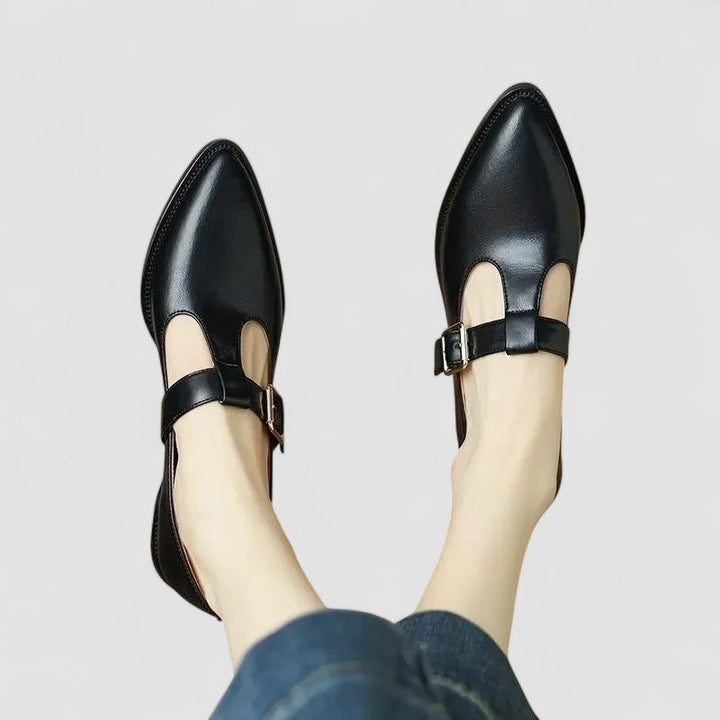 A woman in beige Mary Jane shoes with a mid block heel, poised at a daytime wedding.