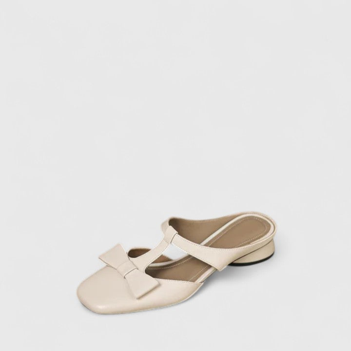 Soft green bow-detail mules with a slim T-strap, open back and a low heel.