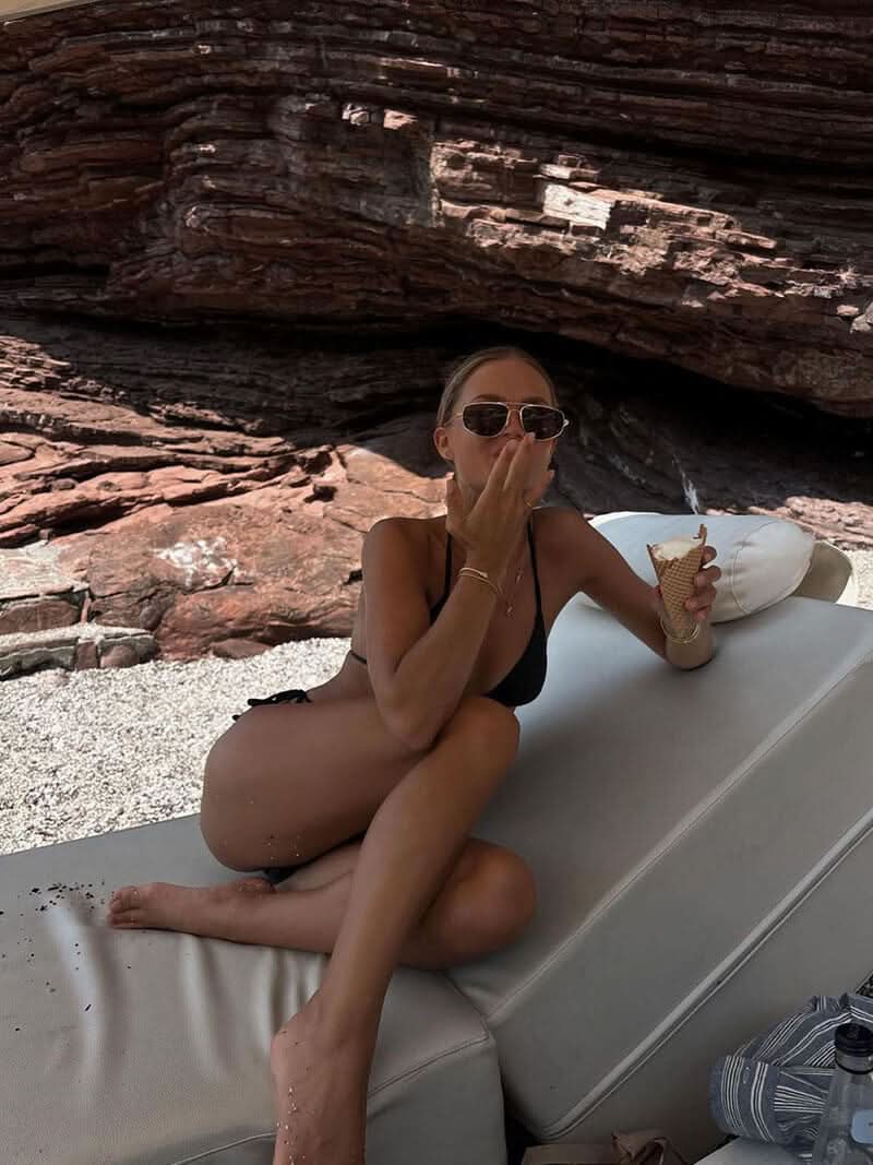 A woman wearing lightweight gold polarised sunglasses on a bright coastal day.