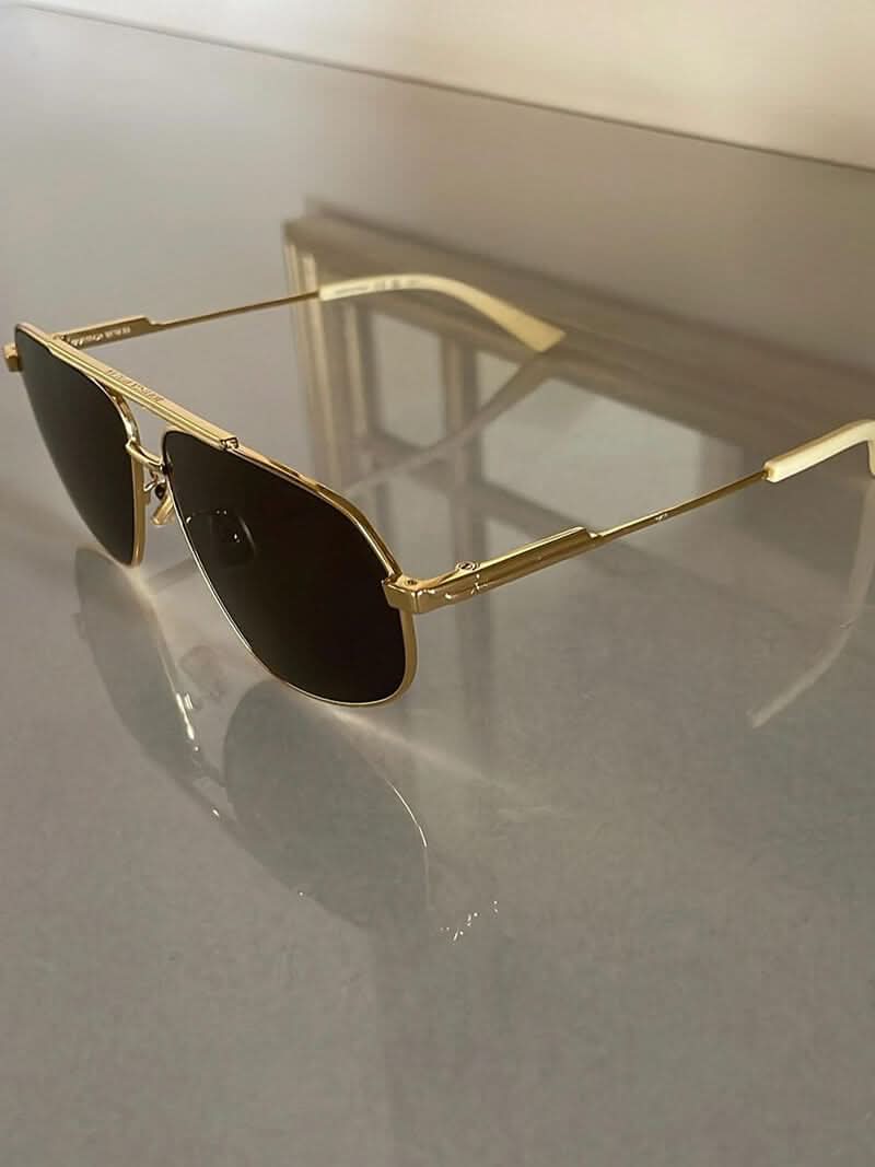 A woman wearing lightweight gold polarised sunglasses on a bright coastal day.