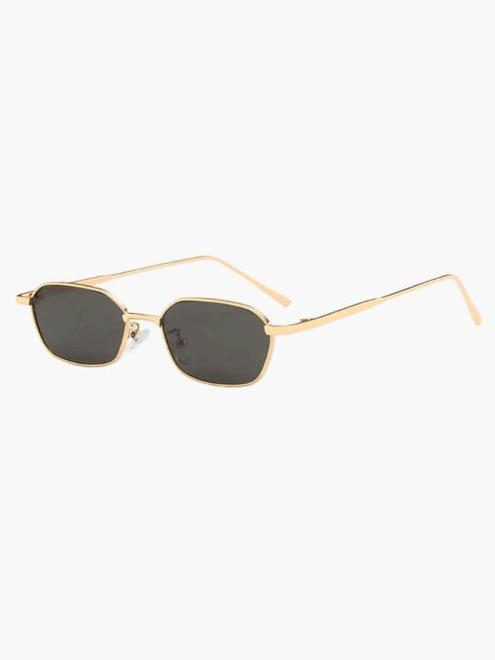 A woman wearing vintage-style gold polarised sunglasses on a sunny day out.