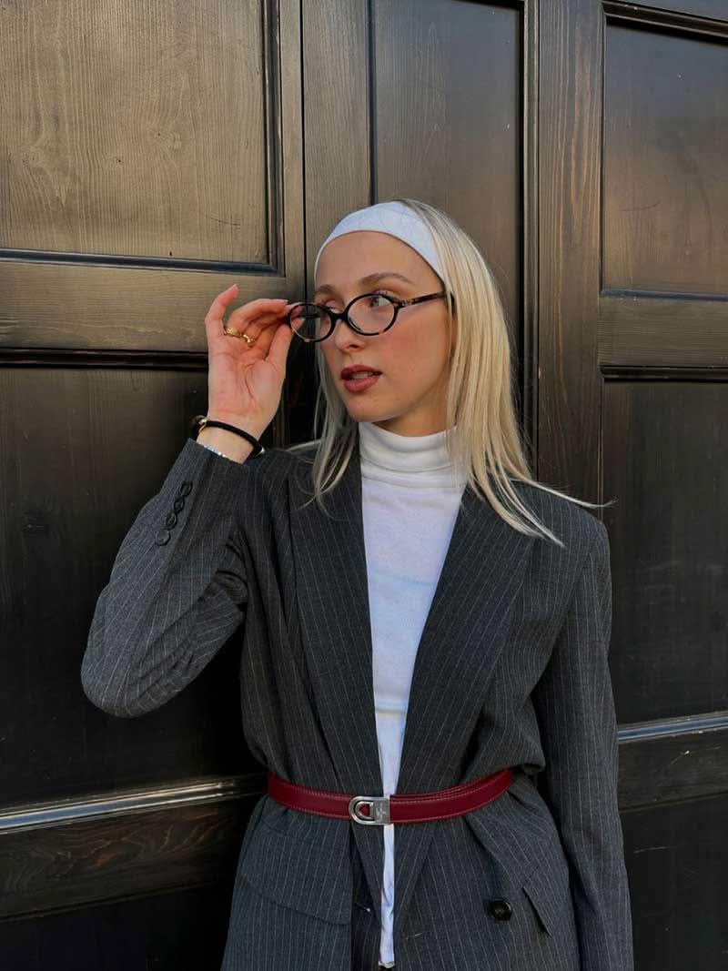 A woman wearing minimalist blue-light reading glasses while relaxing at home.