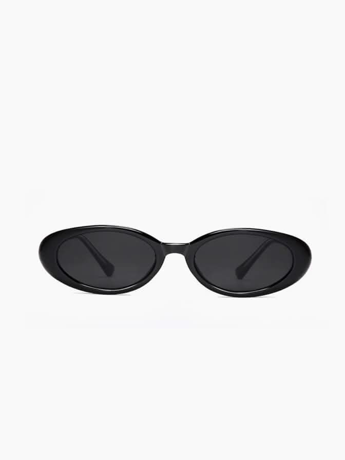A woman wearing oval retro sunglasses while out shopping on a sunny day.
