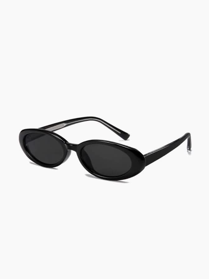 A woman wearing oval retro sunglasses while out shopping on a sunny day.