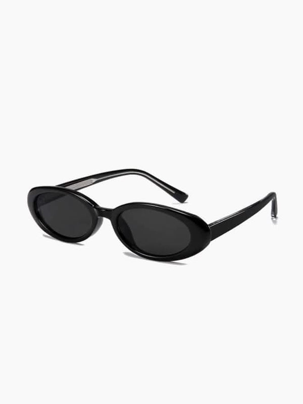 A woman wearing oval retro sunglasses while out shopping on a sunny day.