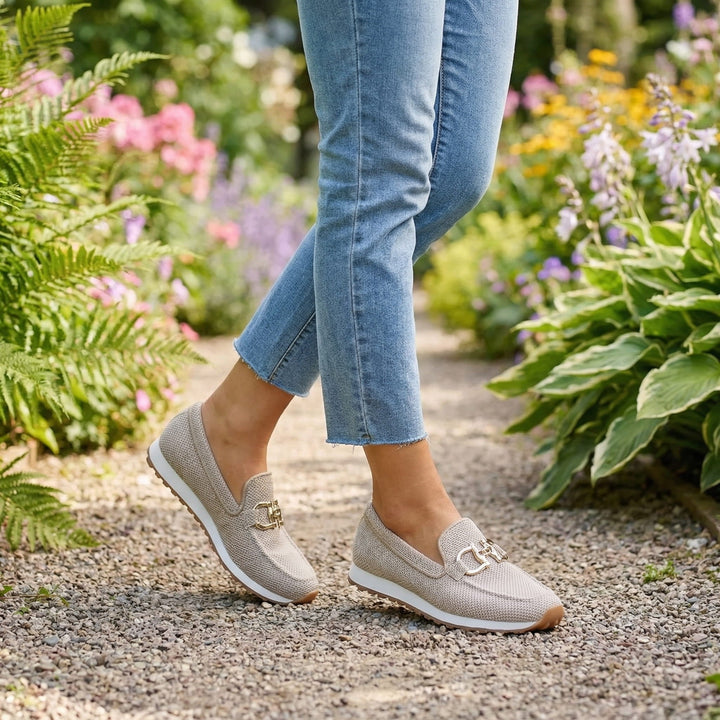 A woman in smart-casual orthopaedic loafer sneakers with a subtle golden detail.