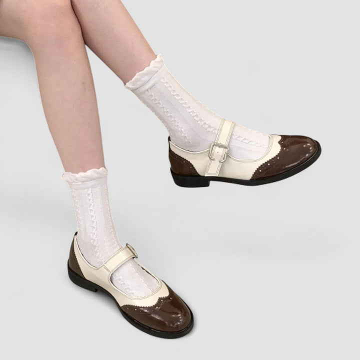 A woman wearing two-tone black and cream Mary Jane shoes, steady and comfortable on an evening out.