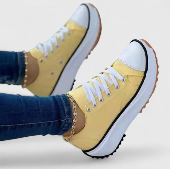 A woman in bold lace-up platform comfort sneakers styled with jeans.