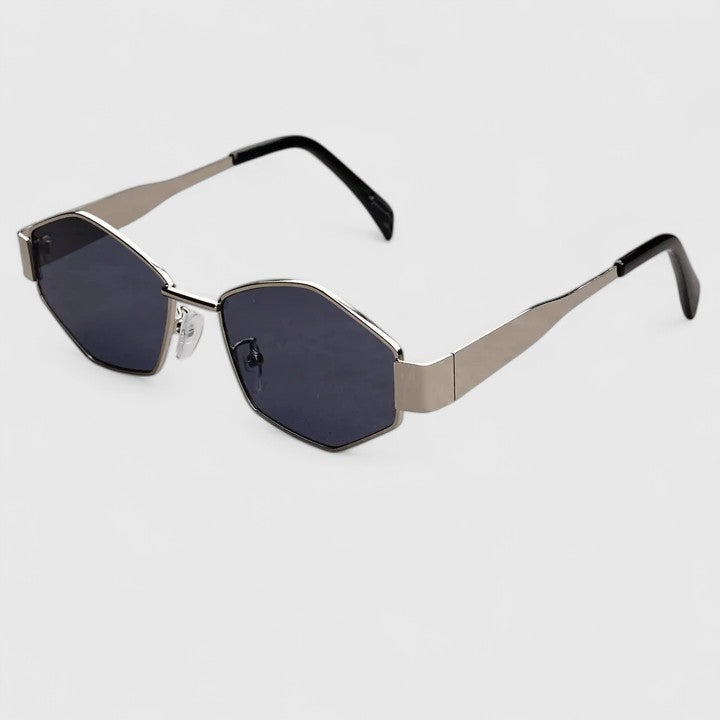 A woman wearing retro hexagonal metal-frame sunglasses on a sunny street.