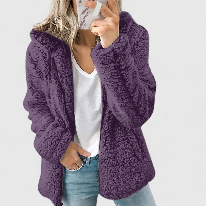 A woman wearing a plush cosy zip jacket over jeans on a cold winter morning.