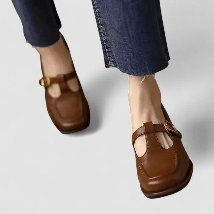 A woman wearing brown T-strap Mary Jane shoes, steady and comfortable through the day.
