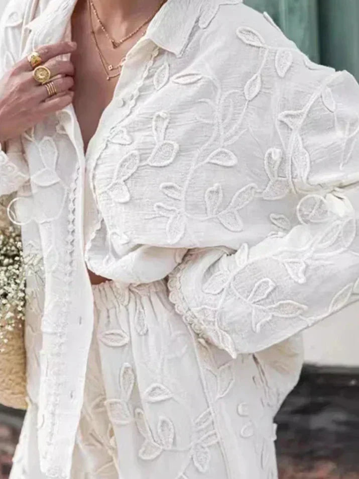 A woman wearing an embroidered relaxed two-piece set with wide pants