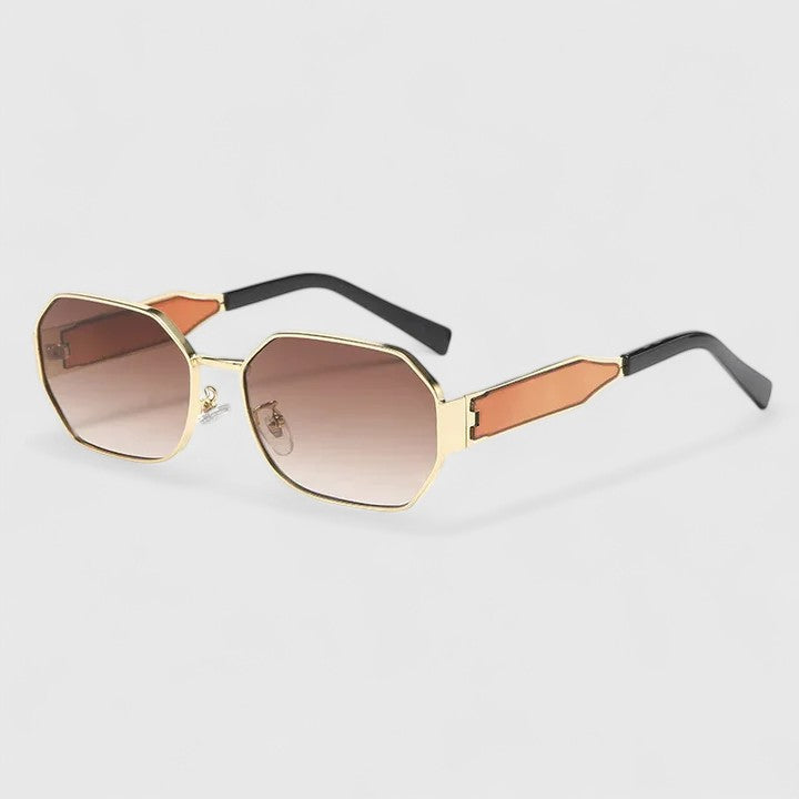 A woman wearing bold geometric gold-accented sunglasses with gradient lenses on a bright day.