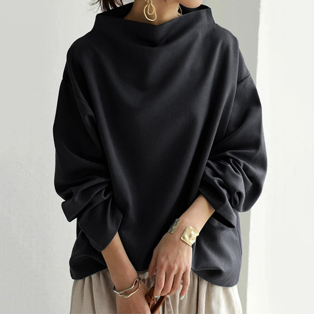 A woman wearing a soft funnel neck sweater styled with jeans for a relaxed elegant look.