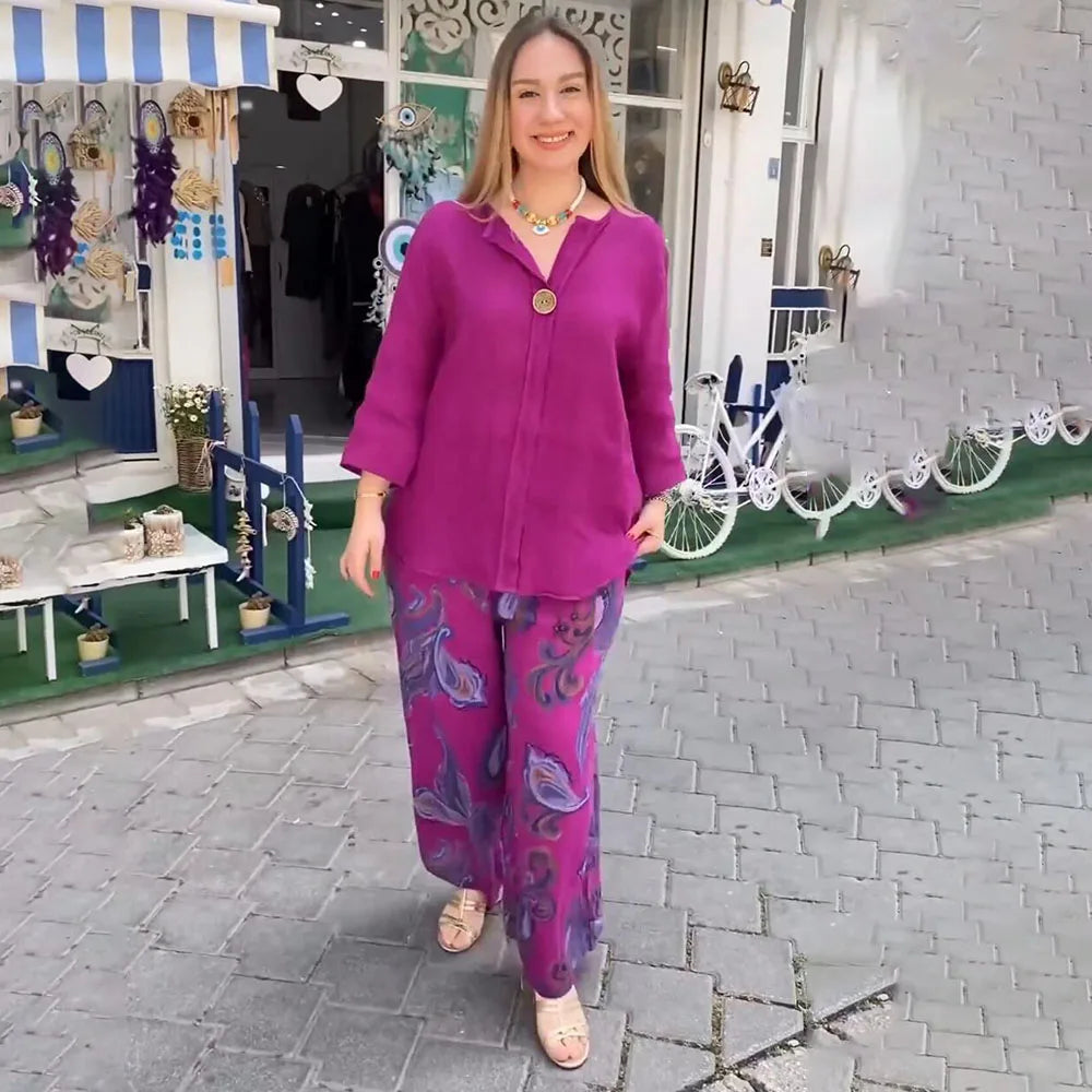 A woman wearing a bright blue blouse with matching patterned wide-leg pants