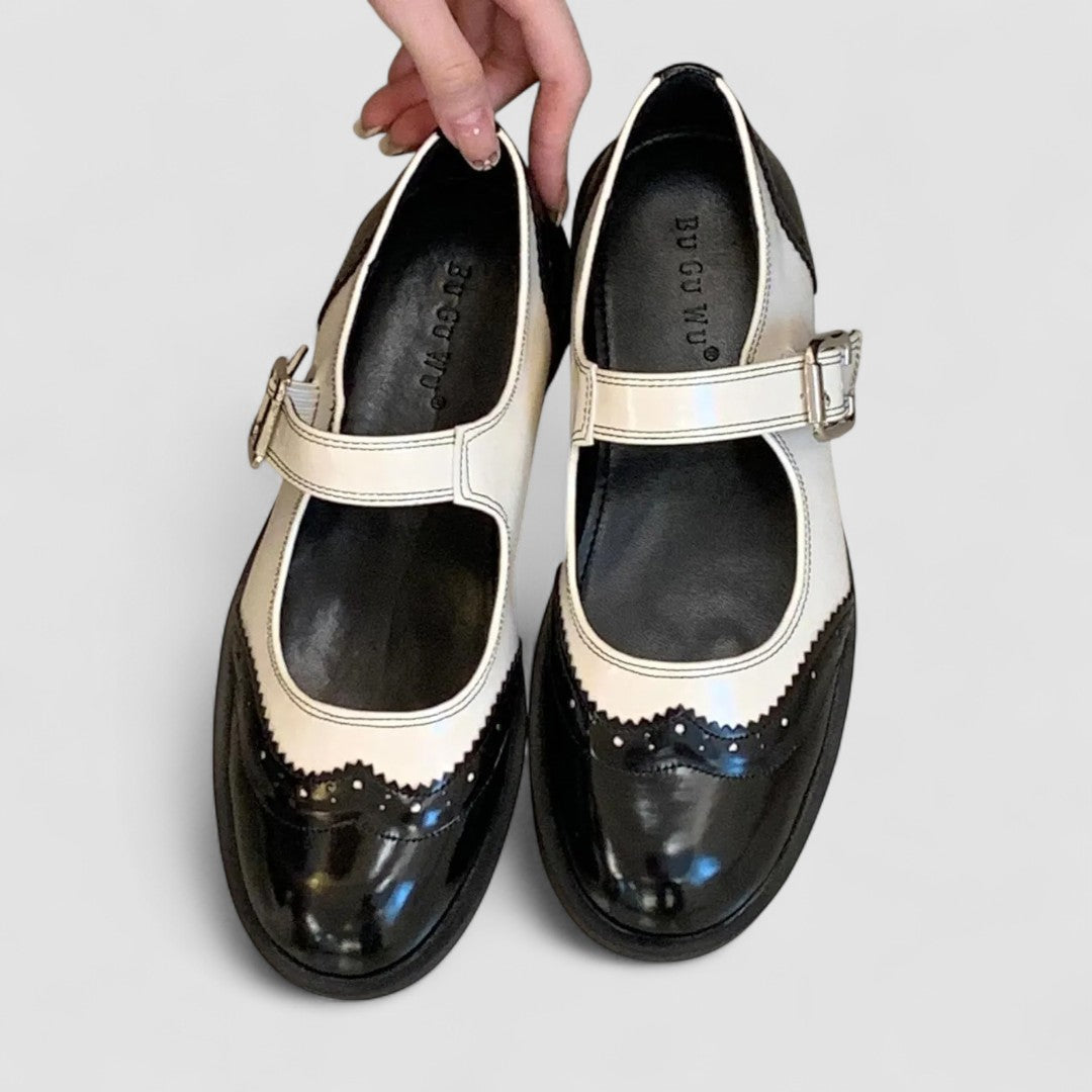 A woman wearing two-tone black and cream Mary Jane shoes, steady and comfortable on an evening out.