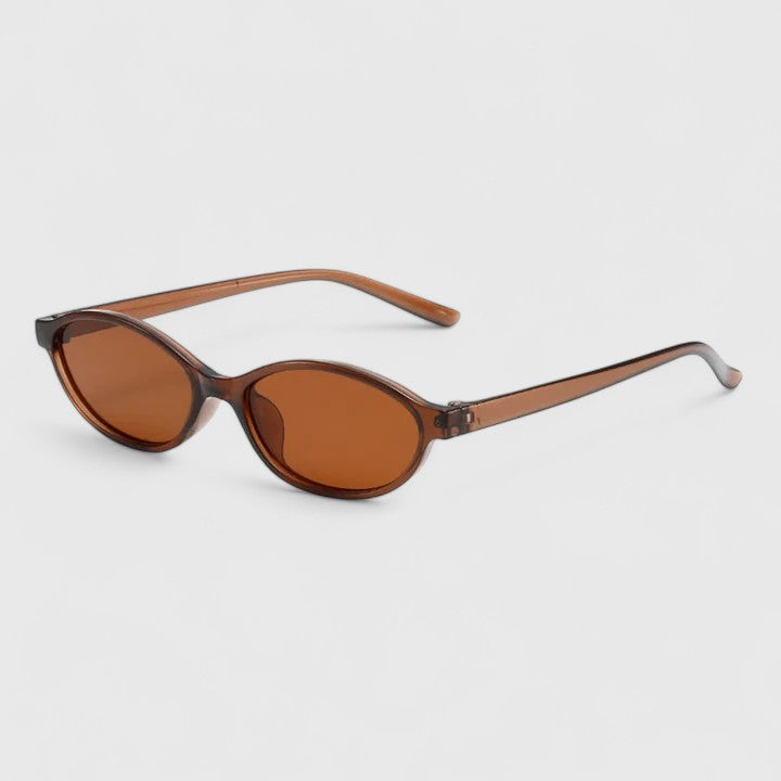 A woman wearing retro oval cat-eye sunglasses on a sunny afternoon.