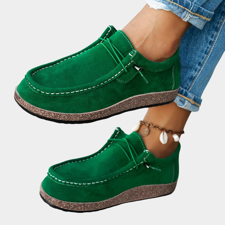 A woman wearing bright green lace-up platform comfort shoes on a walk through the garden.