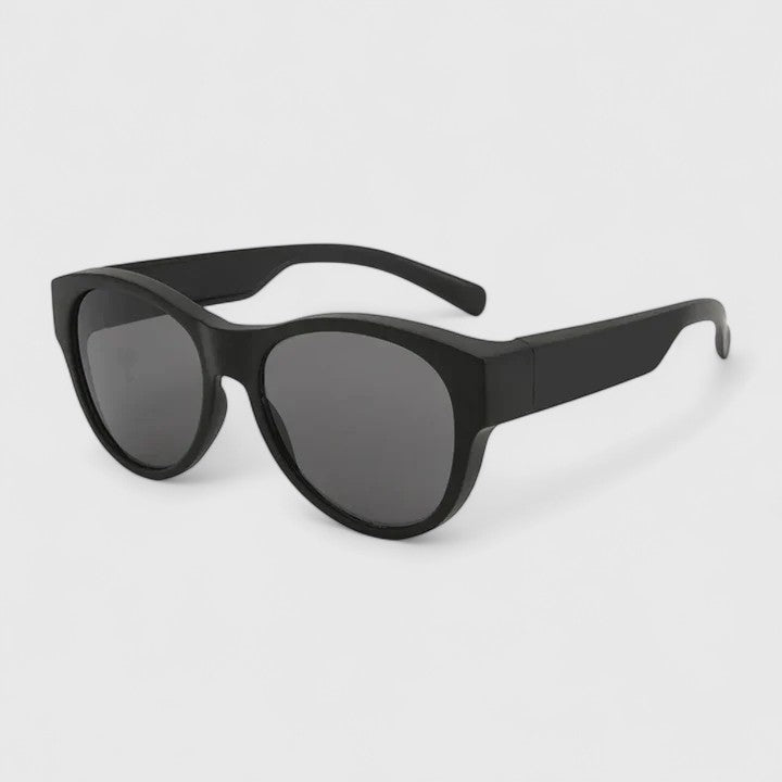 A woman wearing fit-over polarised sunglasses over her own glasses, comfortable in the sunshine.