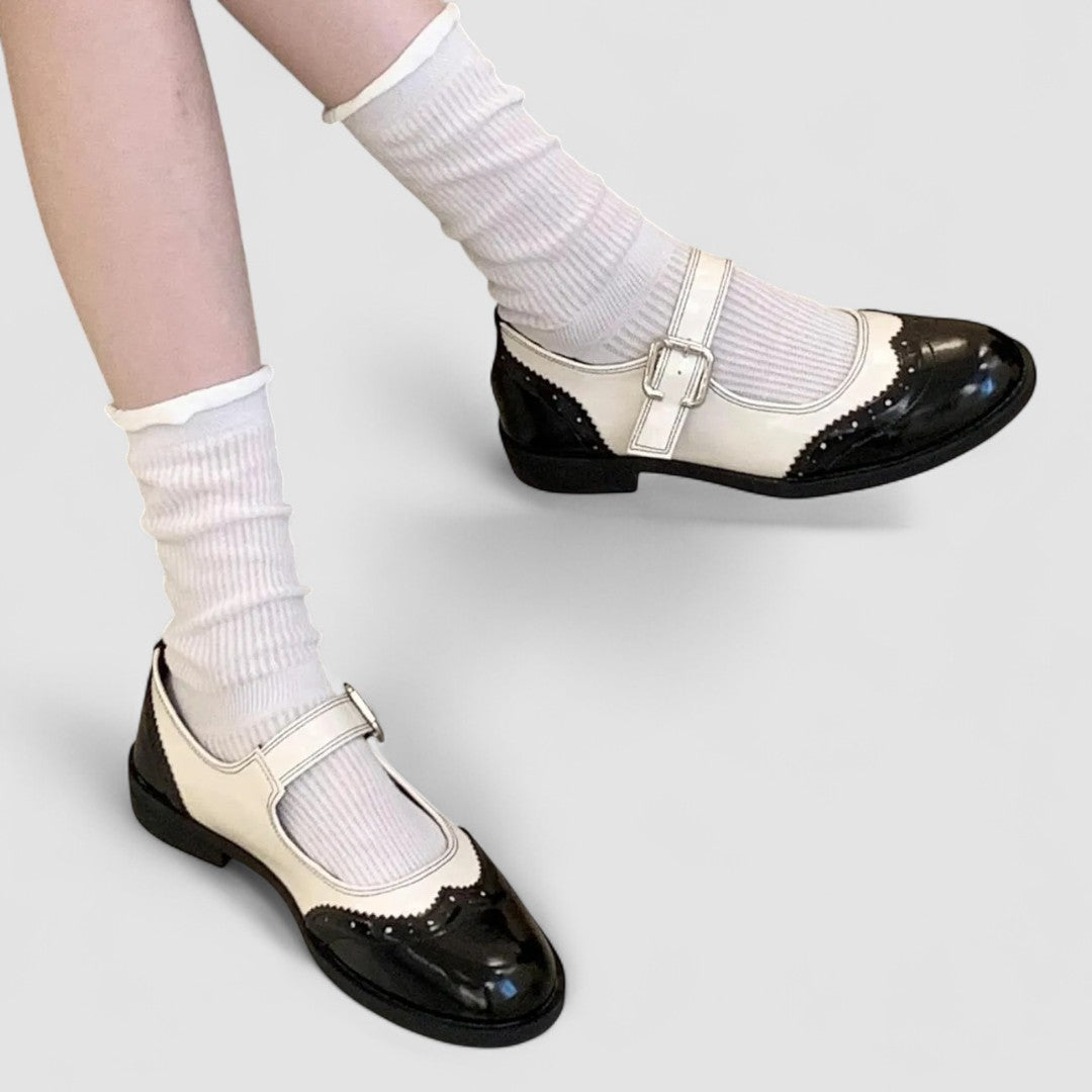 A woman wearing two-tone black and cream Mary Jane shoes, steady and comfortable on an evening out.