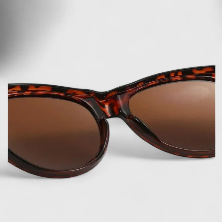 A woman wearing fit-over polarised sunglasses over her own glasses, comfortable in the sunshine.