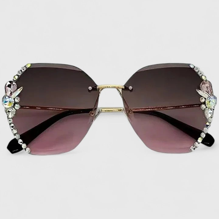 A woman at a special occasion wearing rimless sunglasses with sparkling diamanté accents, catching the light.