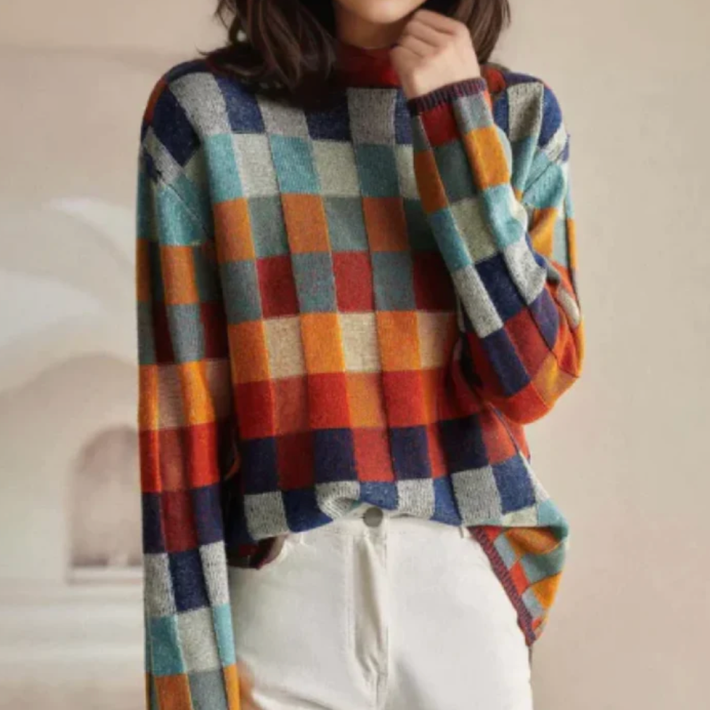 A woman wearing a colourful retro check sweater, relaxed and cosy on a cool fall morning.