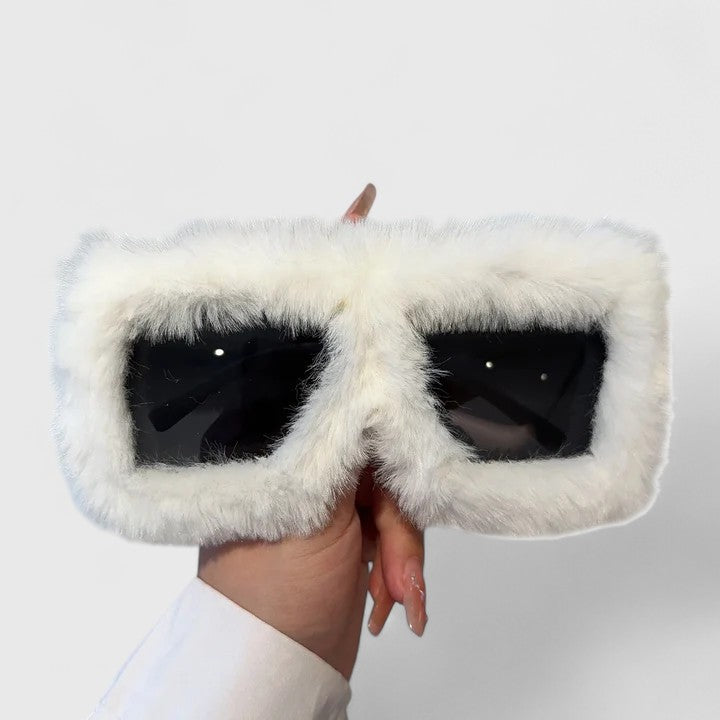 A bold pair of sunglasses with a soft red fluffy trim around the frame and slim black arms.