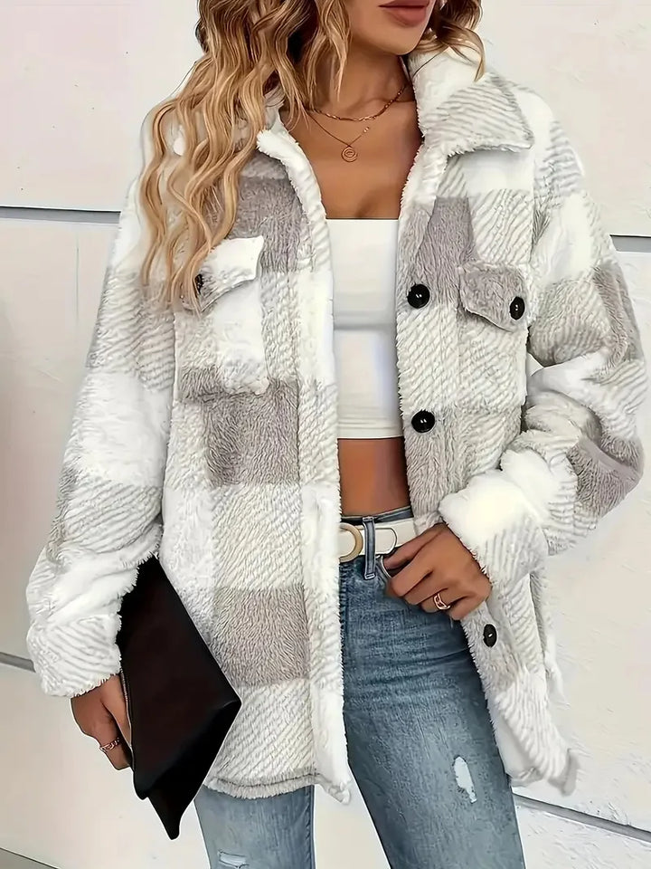 A woman wearing a soft checked jacket over casual clothes on a cool fall morning.