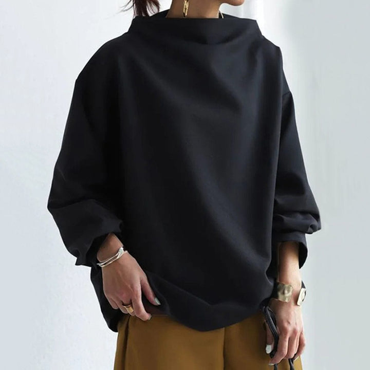 A woman wearing a soft funnel neck sweater styled with jeans for a relaxed elegant look.