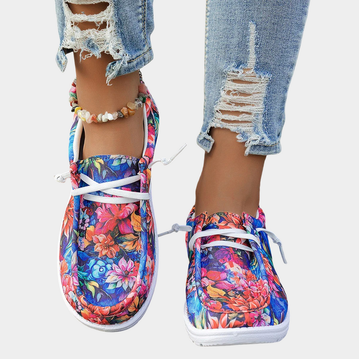 A woman wearing floral-print lace-up comfort shoes on a bright day out.