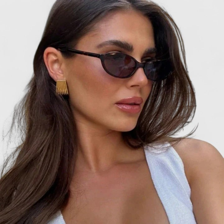 A woman wearing retro oval cat-eye sunglasses on a sunny afternoon.