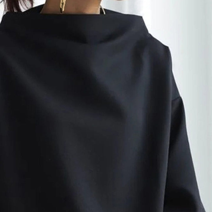 A woman wearing a soft funnel neck sweater styled with jeans for a relaxed elegant look.