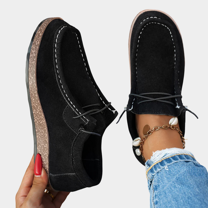 A woman wearing plain black lace-up platform comfort shoes while running errands.