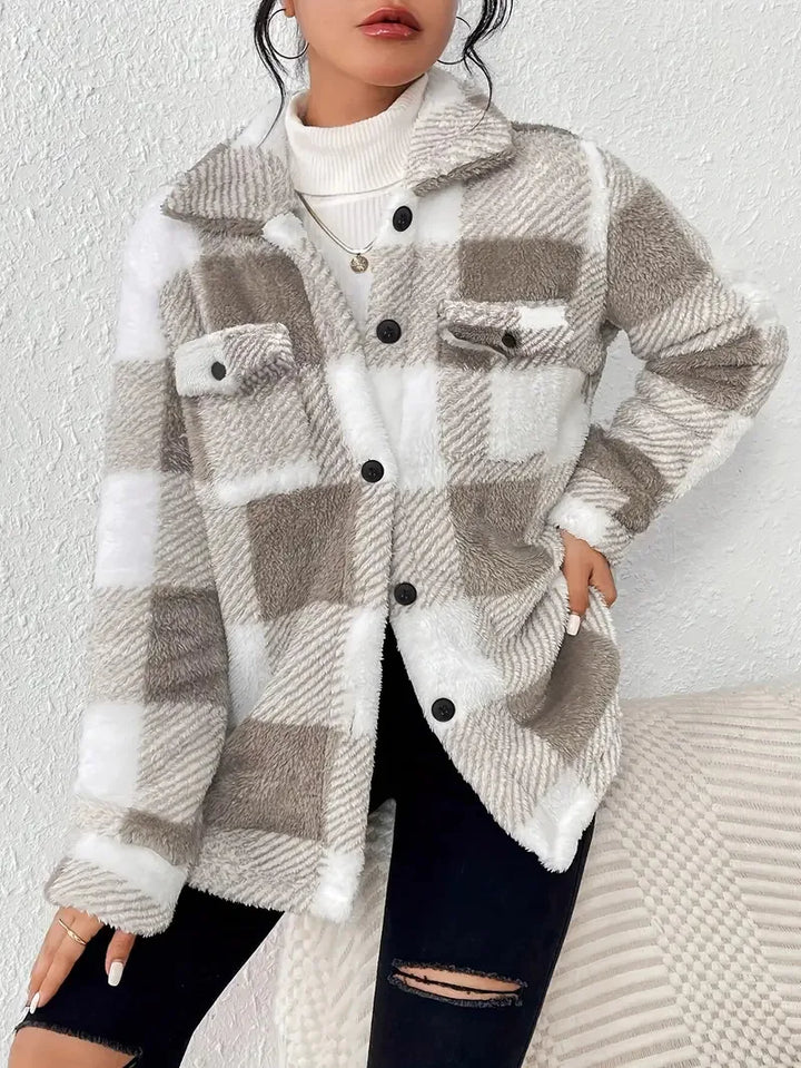 A woman wearing a soft checked jacket over casual clothes on a cool fall morning.