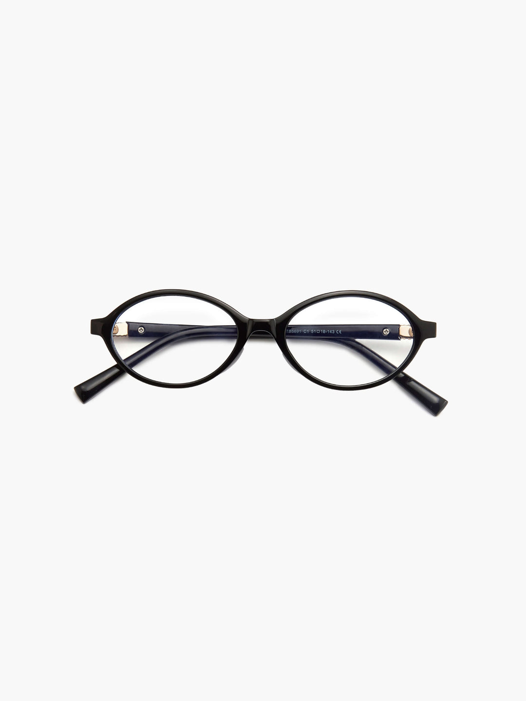 A woman wearing minimalist blue-light reading glasses while relaxing at home.