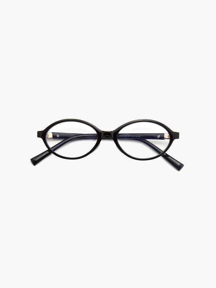 A woman wearing minimalist blue-light reading glasses while relaxing at home.