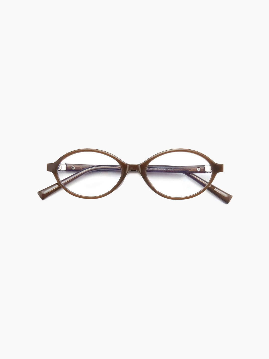 A woman wearing minimalist blue-light reading glasses while relaxing at home.