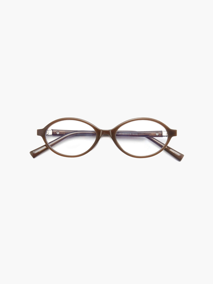A woman wearing minimalist blue-light reading glasses while relaxing at home.